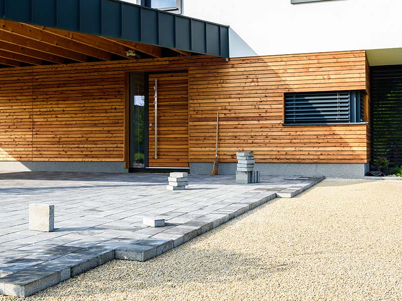 Wood-sided house exterior with a paver patio